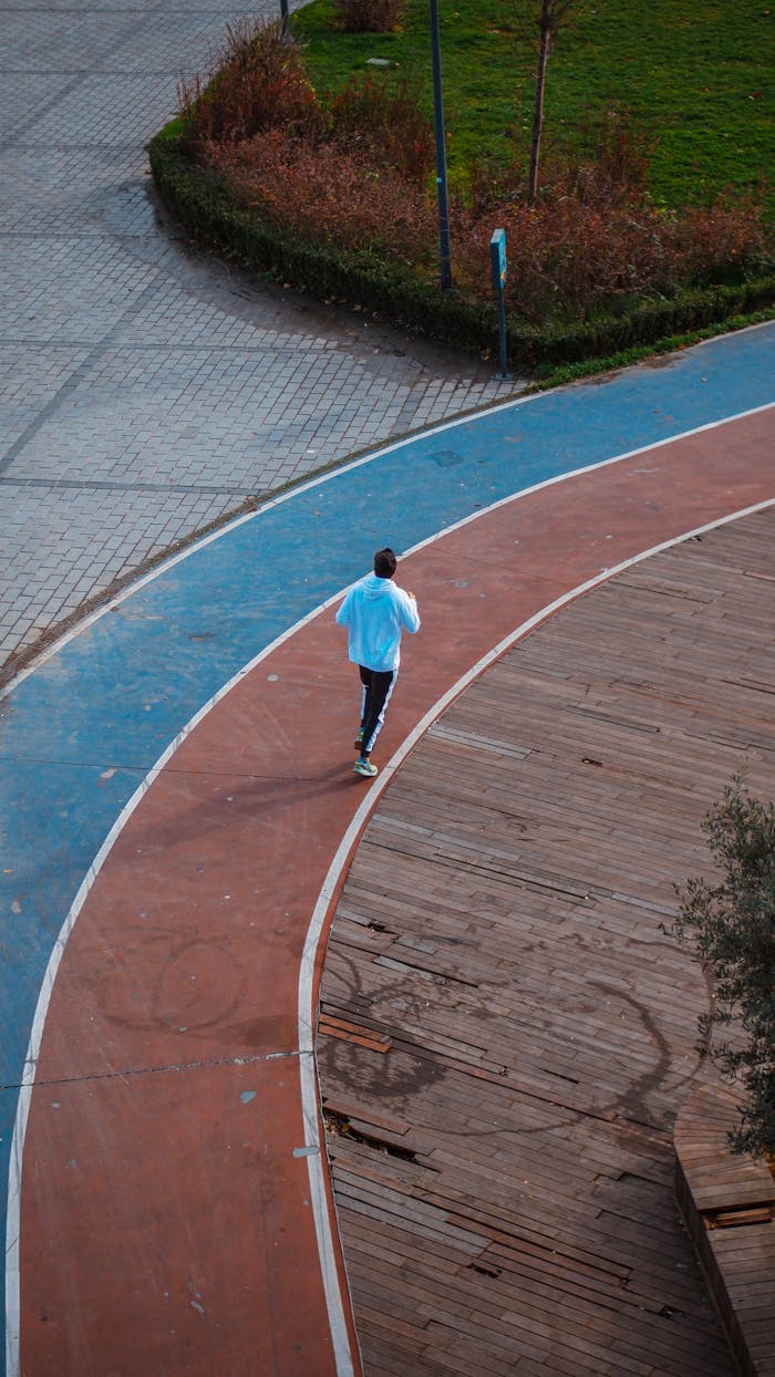 services-01 A runner in sportswear jogs on a colorful track, viewed from above. Vibrant and dynamic.