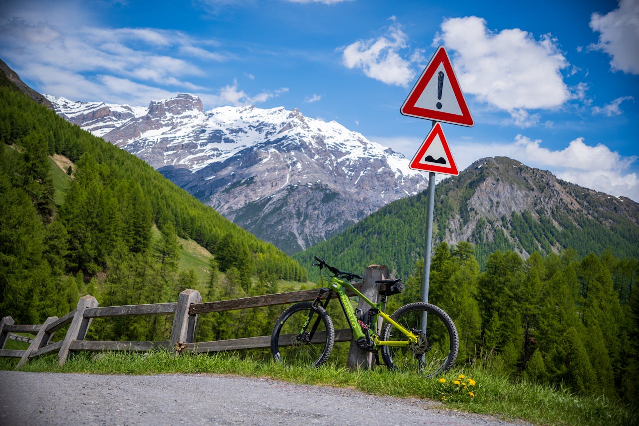 A mountain bike rests on a fence in the scenic Livigno Alps; perfect for summer adventures.